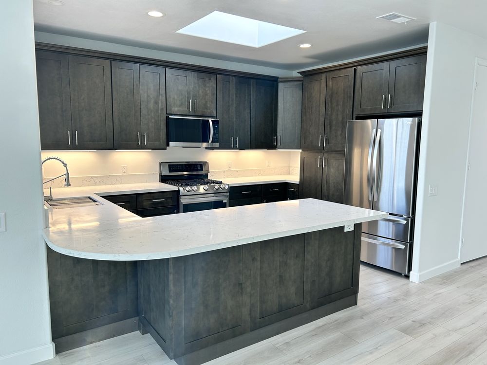 Remodeled rental kitchen with quartz peninsula and dark shaker cabinets